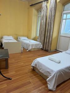 Habitación con 3 camas y suelo de madera. en Baku View Hostel, en Baku 5 fotos más