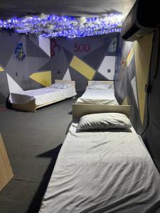 2 camas en una habitación con luces en la pared en Baku View Hostel, en Baku