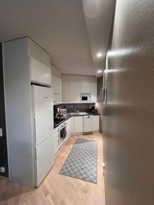 a kitchen with white cabinets and a stainless steel refrigerator at Apartment Secret in Rovaniemi