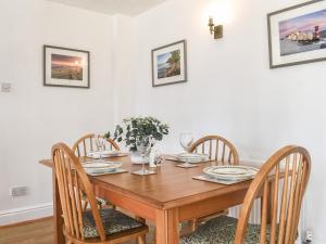 Un comedor con mesa y sillas de madera. en The Coach House - Uk41070, en Wootton Bridge