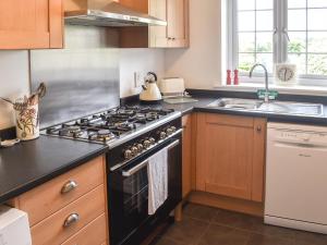 una cocina con estufa y fregadero en The Coach House - Uk41070, en Wootton Bridge
