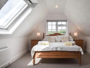 un dormitorio con una cama con sábanas y almohadas blancas en The Coach House - Uk41070, en Wootton Bridge