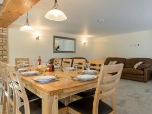 ein Esszimmer mit einem Holztisch und Stühlen in der Unterkunft Eastlands Barn in East Barkwith + 19 Fotos