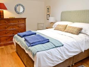 a bedroom with a bed with towels on it at The Barn in Greystoke