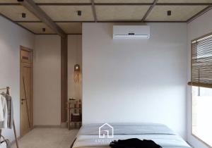 a bedroom with a bed and a white wall at Du già ecolodge in Yên Minh