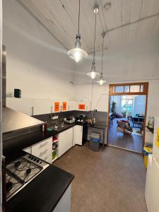 a kitchen with white cabinets and black counter tops at Bee Hostel in Limassol
