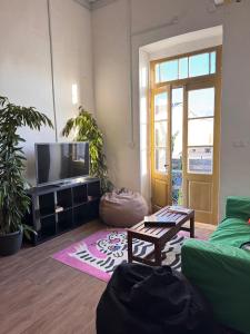 a living room with a couch and a tv at Bee Hostel in Limassol +7 photos