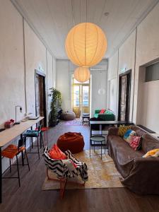 a living room with a couch and tables and a chandelier at Bee Hostel in Limassol