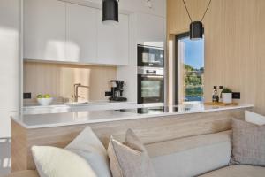 LyngværetにあるLofoten Arctic Lodge - sea view, jacuzzi & saunaのソファとキッチンのあるリビングルーム +45枚の写真