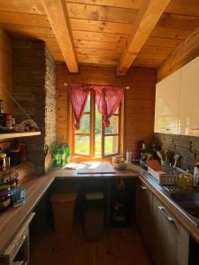 een keuken met een aanrecht en een raam bij Plitvice Waterfall Millhouse Challet Stipanov Mlin in Plitvička Jezera