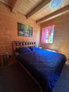 een slaapkamer met een bed in een blokhut bij Plitvice Waterfall Millhouse Challet Stipanov Mlin in Plitvička Jezera