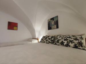een slaapkamer met een wit bed en drie schilderijen bij Casa vacanza Gallipoli centro in Gallipoli +7 foto's