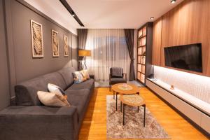 a living room with a couch and a tv at Modern Mountain - Comfort Apartment in Kolašin