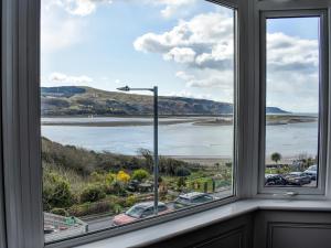 ein Fenster mit Blick auf einen Wasserkörper in der Unterkunft Ty Isaf in Barmouth
