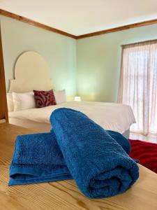 a blue towel sitting on top of a bed at Colline Sainté Cottage in Port Alfred