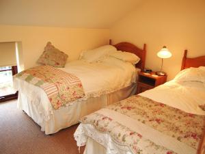 MelmerbyにあるElseghyll Barnのベッドルーム1室(ベッド2台、ランプ付きテーブル付) +4枚の写真