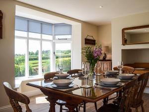 een eetkamer met een tafel en een groot raam bij Barnleigh in Ludlow +23 foto's
