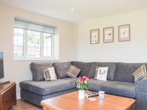 een woonkamer met een bank en een tafel bij Barnleigh in Ludlow