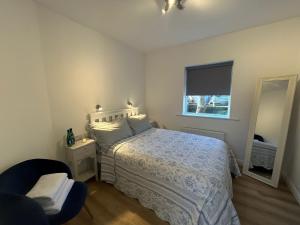 Schlafzimmer mit einem Bett, einem Fenster und einem Spiegel in der Unterkunft Westport Coastal Cottage in Westport