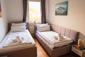 ein kleines Zimmer mit 2 Betten und einem Sofa in der Unterkunft Ruhiges 5-Personen Apartment mit kostenlosen Parkplätzen, Boxspringbetten, WLAN, 3x TV, vollausgestatteter Küche 