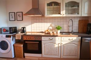 eine Küche mit Herd, Spüle und Geschirrspüler in der Unterkunft Ruhiges 5-Personen Apartment mit kostenlosen Parkplätzen, Boxspringbetten, WLAN, 3x TV, vollausgestatteter Küche 