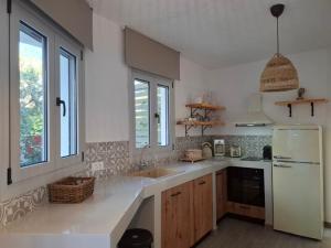 アファンドウにあるRhodes Soul luxury suitesの白い冷蔵庫とシンクのあるキッチン