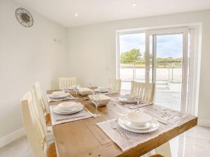 a dining room with a wooden table with white dishes at Penlon Cwrws in Llangynllo