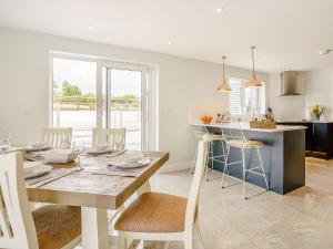 a kitchen and dining room with a wooden table and chairs at Penlon Cwrws in Llangynllo