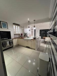 eine große Küche mit Spüle und Herd in der Unterkunft Life's A Beach - cosy, luxury cottage in Ashley Cross, Poole in Parkstone