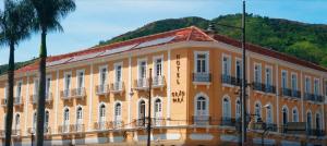 an orange building with a mountain in the background at Grão Pará Petrópolis in Petrópolis