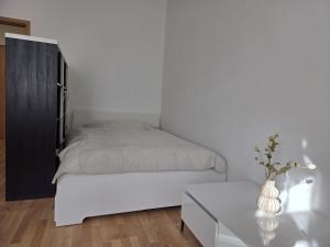 a white bedroom with a bed and a table at Große, moderne, helle Unterkunft mit Essküche all-in LTE in Gera