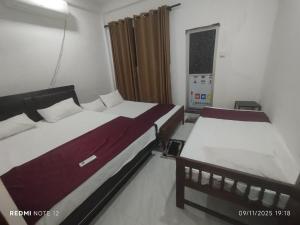 a bedroom with two beds and a window at Randuli Holiday Homes in Anuradhapura