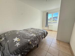 a bedroom with a bed with a blanket on it at Maison plain-pied in Saint-Clair