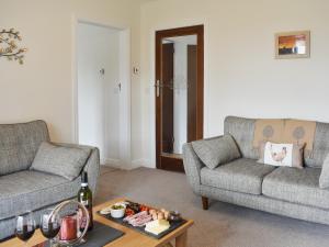 ein Wohnzimmer mit zwei Sofas und einem Tisch in der Unterkunft Manor Park Cottage in Knitsley