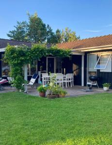 ein Haus mit einer Terrasse mit Tisch und Stühlen in der Unterkunft Family House With Large Garden Near Ebeltoft in Ebeltoft
