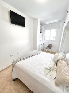 - une chambre blanche avec un lit et une télévision murale dans l'établissement Piso céntrico Corazón de Aridane, à Los Llanos de Aridane 23 autres photos