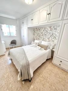 - une chambre blanche avec un grand lit et un mur dans l'établissement Piso céntrico Corazón de Aridane, à Los Llanos de Aridane