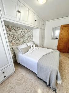 a bedroom with a white bed and a stone wall at Piso céntrico Corazón de Aridane in Los Llanos de Aridane