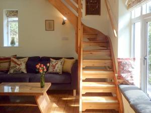 ein Wohnzimmer mit einem Sofa und einer Holztreppe in der Unterkunft Heale Cottage - 28087 in Littleham