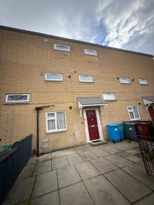 een groot bakstenen gebouw met een rode deur bij Private Room & shower- Near Central Manchester in Manchester