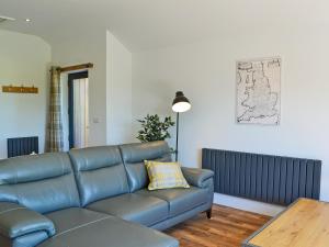 a living room with a blue couch and a table at Harry's Den in Chapel Saint Leonards