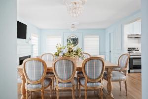 a dining room with a wooden table and chairs at Downtown 10 min, 90 degree F Pool & Spa, Linked 2 homes, Gated Parking in Houston