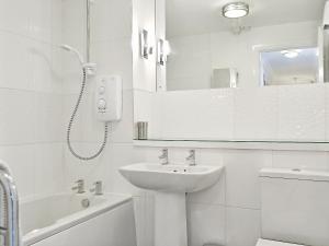 a white bathroom with a sink and a mirror at Herdwick Heights in Keswick