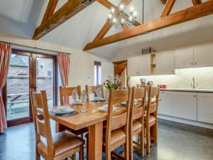 SculthorpeにあるWoodpecker Barn - Cwlの木製のテーブルと椅子のあるキッチンとダイニングルーム +16枚の写真