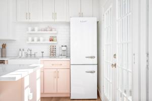 a kitchen with white cabinets and a white refrigerator at Downtown 10 min, 90 degree F Pool & Spa, Linked 2 homes, Gated Parking in Houston