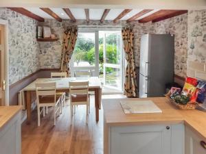 a kitchen with a table and a refrigerator at Brompton Lodge in Ganton