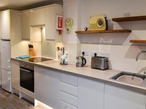 a kitchen with white cabinets and a sink at Myrtle Loft in Instow