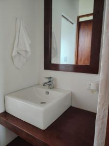 ein Badezimmer mit einem weißen Waschbecken und einem Spiegel in der Unterkunft Casa Blanca in Cajicá