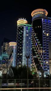 a large building with lights on it at night at BATUMi ORBI GRAND APART HOTEL in Batumi