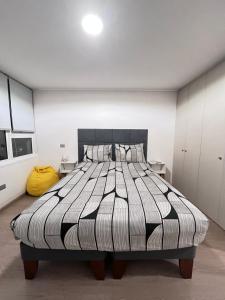 Ένα ή περισσότερα κρεβάτια σε δωμάτιο στο Descanso soleado centro de Conce +2 φωτογραφίες